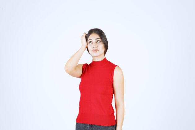 服装穿红衬衫的女孩摆出中性 积极和吸引人的姿势年轻工人人类