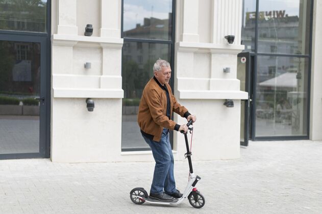 城市骑滑板车的中枪老头男人户外生活方式