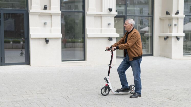 男人拿着滑板车的中枪老头户外生活方式滑板车