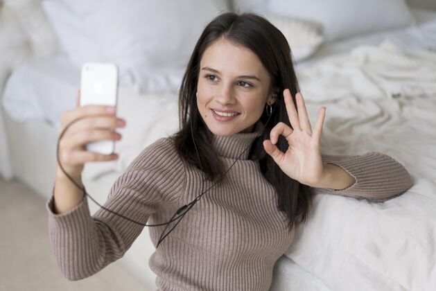 设备手机上有视频通话的女人在线通信房子
