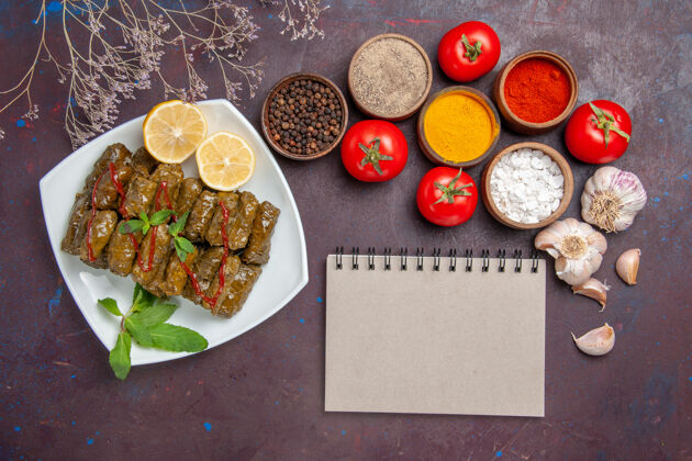 胡椒俯瞰美味的叶多尔玛与调味品和西红柿对黑暗的背景肉菜叶食品晚餐一餐晚餐宴会餐馆