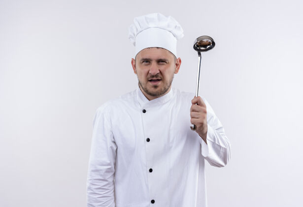 厨师自信的年轻帅哥厨师身着厨师制服 拿着勺子站在孤零零的白墙上厨艺自信年轻