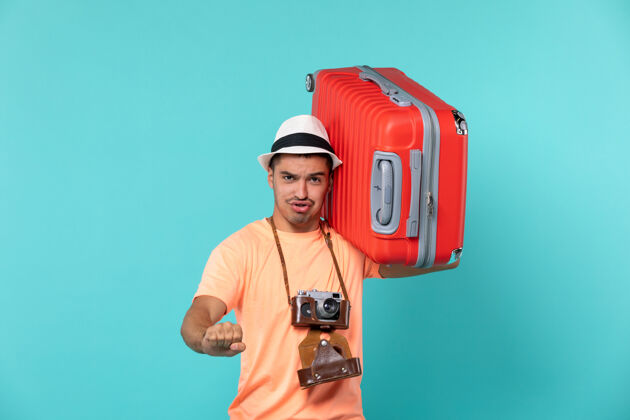 蓝色度假的男人拿着蓝色的大红色手提箱假期旅程红色