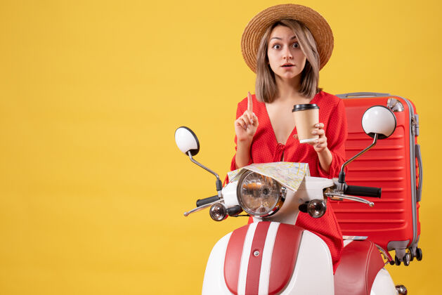 杯子一位穿着红裙子的年轻女士拿着咖啡杯 坐在轻便摩托车旁边人咖啡时尚
