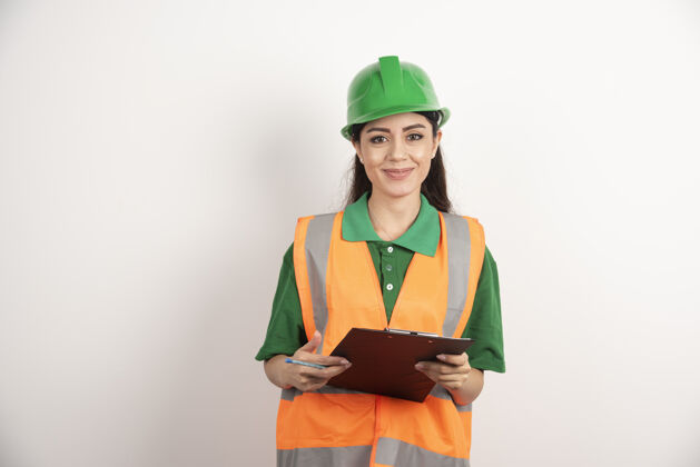 头盔年轻的女工程师微笑着拿着剪贴板高质量的照片承包商人工人