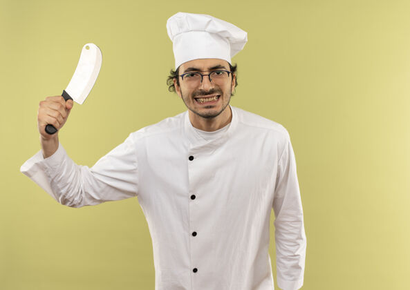 烹饪看起来很高兴年轻的男厨师穿着厨师制服和眼镜提出绿色背景切割器眼镜制服男性
