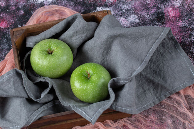 水果绿色的苹果放在灰色的厨房毛巾上蔬菜容器篮子