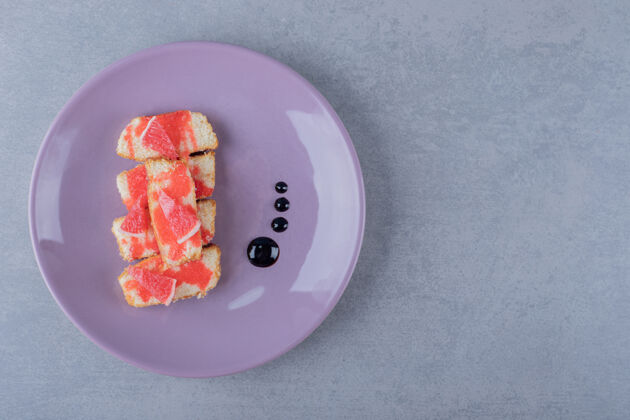 美味紫色盘子上的自制柚子蛋糕饼干填充蛋糕