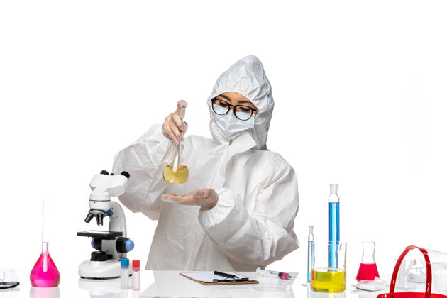 外套正面图身穿特殊防护服的年轻女化学家拿着烧瓶 背景是白色的实验室冠状病毒化学病毒医生医学医学