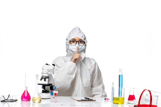 防护前视图身着特殊防护服的年轻女化学家要求对白色背景病毒实验室冠状病毒保持沉默-化学化学专业套装