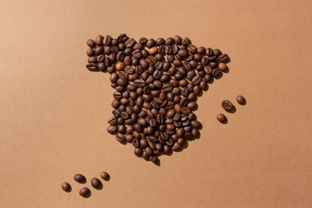 组用咖啡豆在棕色表面制作的西班牙地图棕色咖啡艺术家