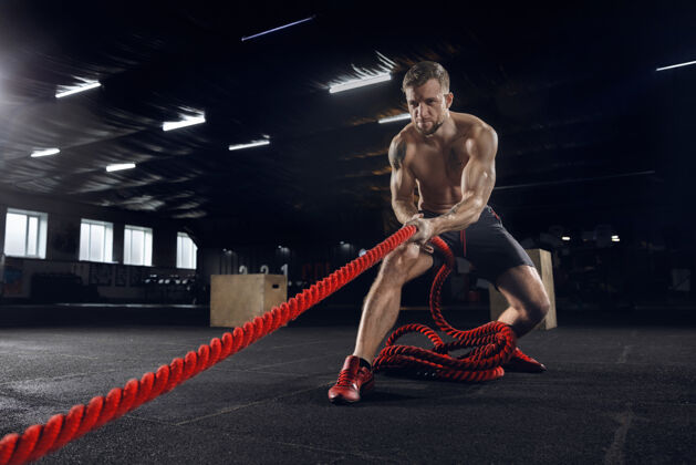 肌肉年轻健康的人 在体育馆里用绳子锻炼的运动员交叉教练站立