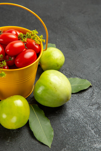 蔬菜底部近距离观看黄色桶装满樱桃西红柿和莳萝花 绿色西红柿环绕在深色背景上农业素食新鲜