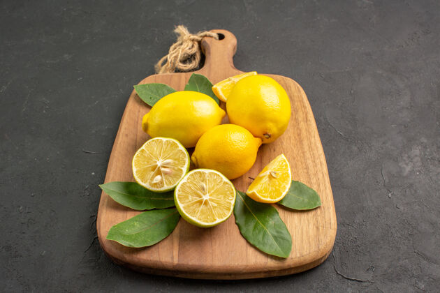 柑橘正面是深灰色背景上的新鲜柠檬酸水果树多汁柠檬