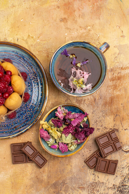 健康一杯热凉茶的俯视图水果和鲜花巧克力软蛋糕碗托盘茶