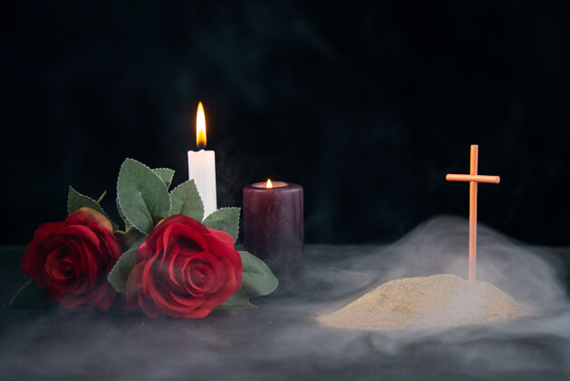 蜡烛在黑暗的表面上 有蜡烛和鲜花作为记忆的小坟墓烛光黑暗火焰
