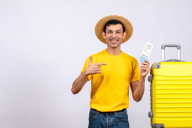 黄色正面图年轻游客站在黄色手提箱旁指着机票前面男站
