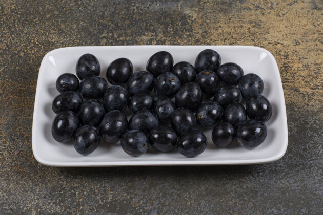 有机新鲜的黑葡萄放在白色的方形盘子里健康新鲜自然