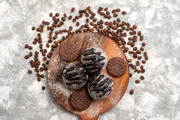 茶俯瞰美味的巧克力蛋糕 白色表面有饼干和咖啡籽水果食用坚果饼干
