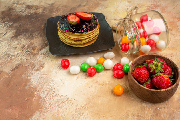 健康正面图木制桌上有彩色糖果的甜煎饼蛋糕甜点甜馅饼糖果甜点糖果