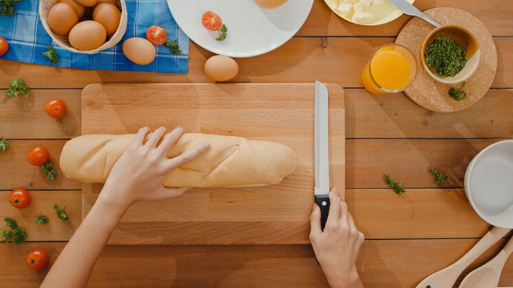 酸面团年轻的亚洲女厨师手拿刀在木板上切全麦面包板有机小麦