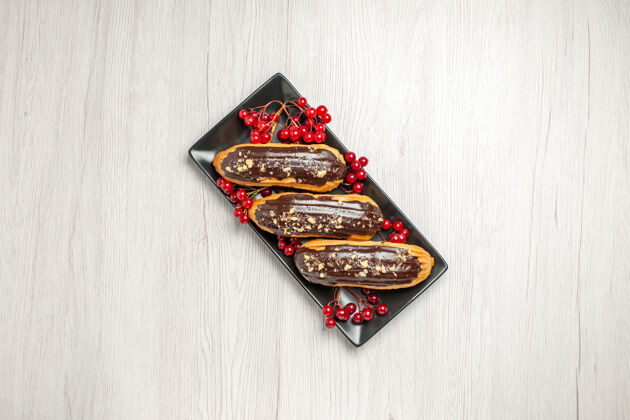 书签上图：白色木质地面中央的黑色矩形板上的巧克力和醋栗棕色食物礼物
