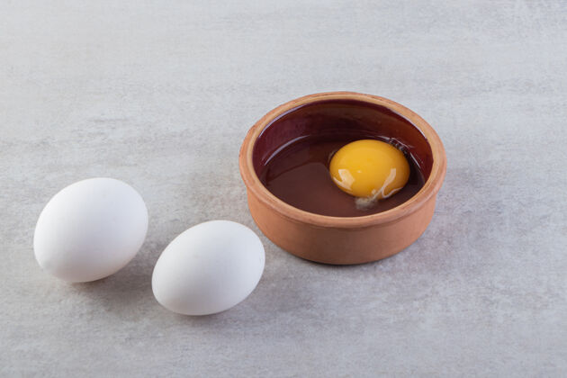 未煮熟的把新鲜的生鸡蛋放在石头上未经料理的母鸡食物