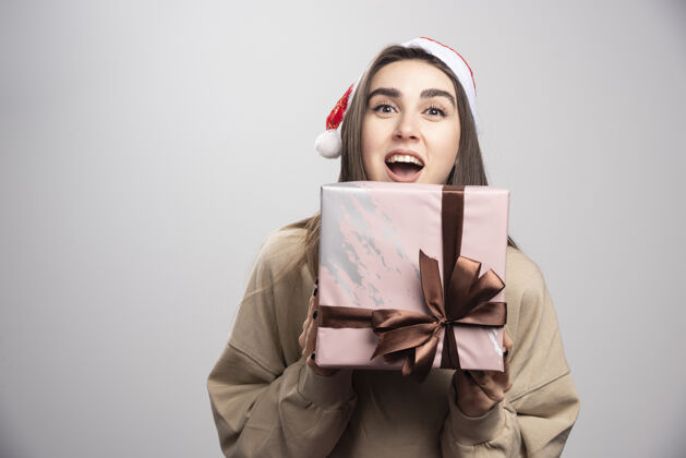 人年轻女子为一盒圣诞礼物兴奋不已漂亮携带礼物