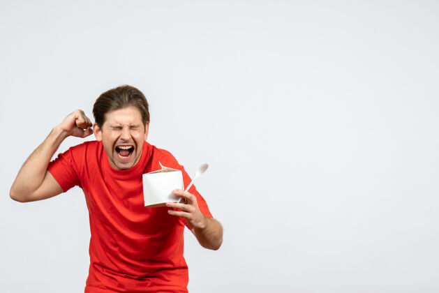 勺子正面图是一个穿着红色上衣 手持纸盒和勺子 背景为白色 情绪激动的年轻人人持有人