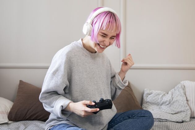 玩家粉红色头发的年轻女子在玩电子游戏游戏杆技术娱乐