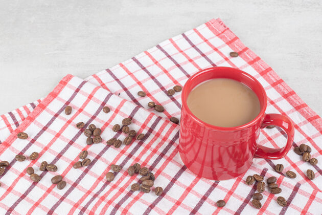 马克杯一杯红咖啡 咖啡豆放在桌布上食物营养咖啡