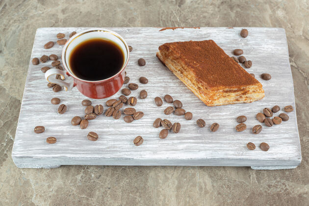 配料一杯咖啡豆和糕点放在木板上美味糕点热