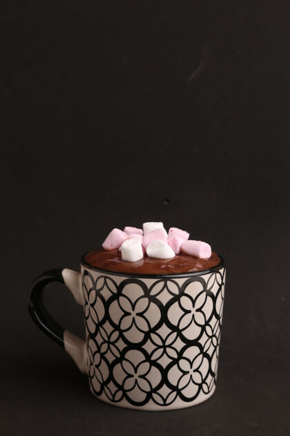 早餐垂直拍摄的装饰马克杯与热巧克力和棉花糖上的黑色可口美味巧克力