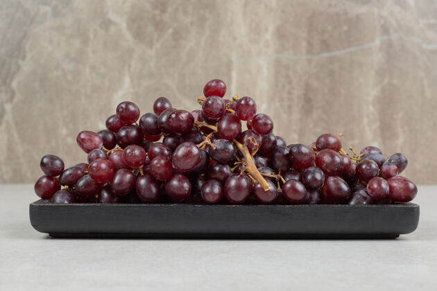 美味新鲜的红葡萄放在黑盘子里新鲜天然葡萄