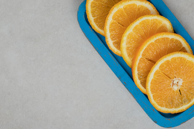 食物新鲜的橘子片放在蓝色盘子里切片膳食多汁
