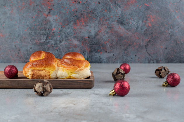 辛辣在大理石桌上放圣诞球和甜面包托盘美味装饰品