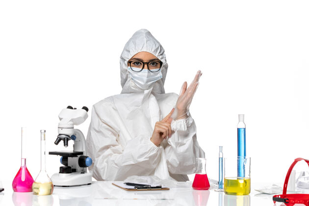 流行病前视图穿着特殊防护服的女化学家坐在白色化学大流行的冠状病毒的背景上套装女化学家外套