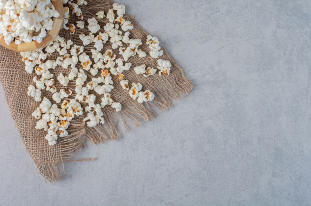 爆米花爆米花放在碗里 撒在大理石表面的一块布上电影院黄油垃圾食品