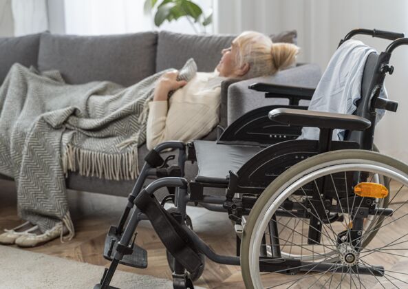 老年人老太太躺在轮椅旁边的床上护理医疗健康