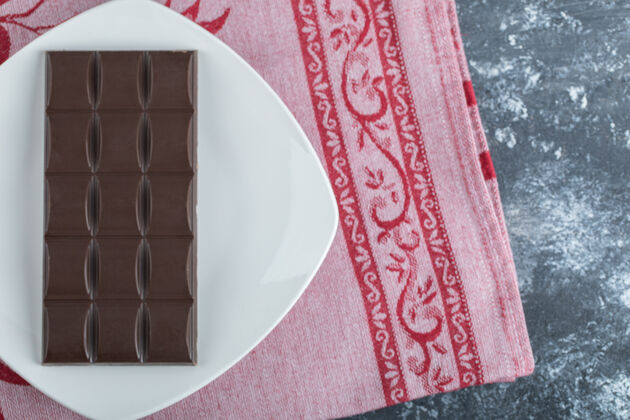 可可一块美味的巧克力放在白色盘子里糖块糖果
