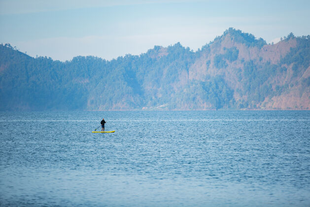 娱乐一个男人在湖边骑冲浪板冲浪板湖泊人