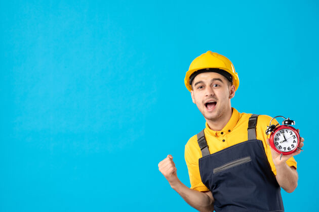 建筑师正面图：身着黄色制服 蓝色挂钟的欢呼男工人建筑商建筑修理工