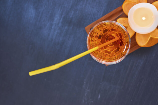 热橘子和一杯果汁 黄色的烟斗放在顶角的木盘上高质量的照片冷鸡尾酒极简