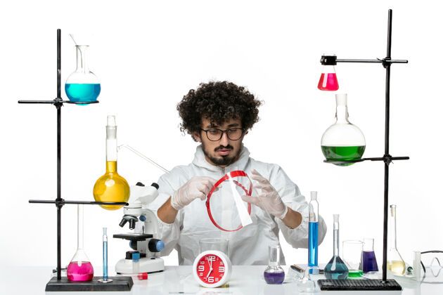实验室正面图年轻的男科学家穿着白色的特别套装拿着什么研究化学瓶子