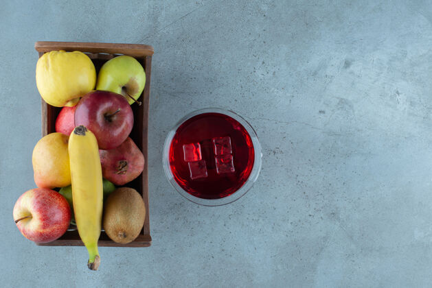 鸡尾酒美味的果汁加冰块和各种水果木头立方体篮子