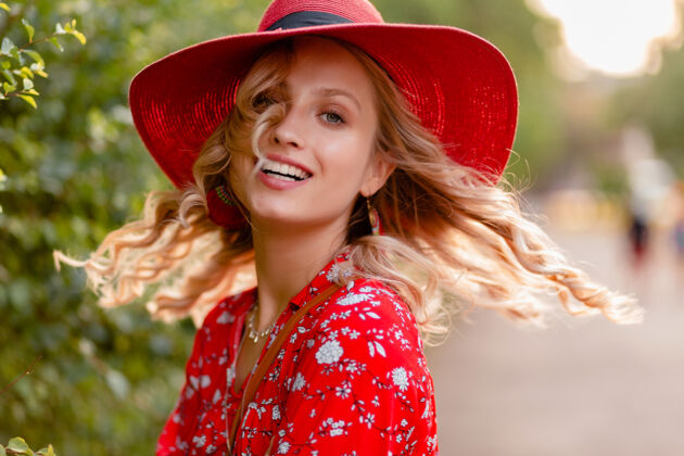 白色近距离肖像迷人的时尚金发微笑的妇女在稻草红色帽子和衬衫夏季时尚套装与微笑卷曲的发型女人金发华丽