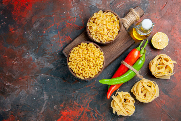 农产品上图：生面团和辣椒用绳子绑在一起 油瓶柠檬蒜放在五颜六色的桌子上油胡椒粉晚餐