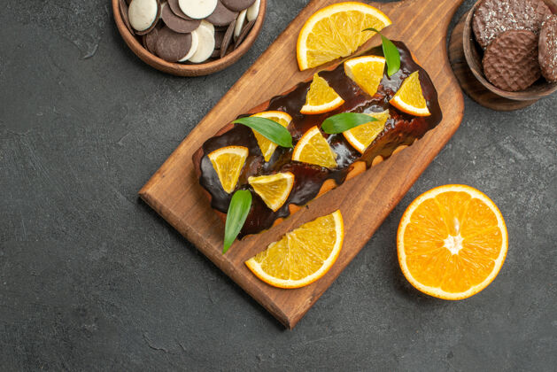 新鲜上图：美味的蛋糕切柠檬和饼干放在黑暗的烤箱地板上容器饼干板