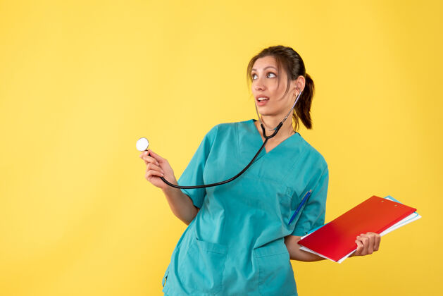 肖像前视图穿着医用衬衫的女医生 黄色背景上有听诊器和注释健康黄色女医生