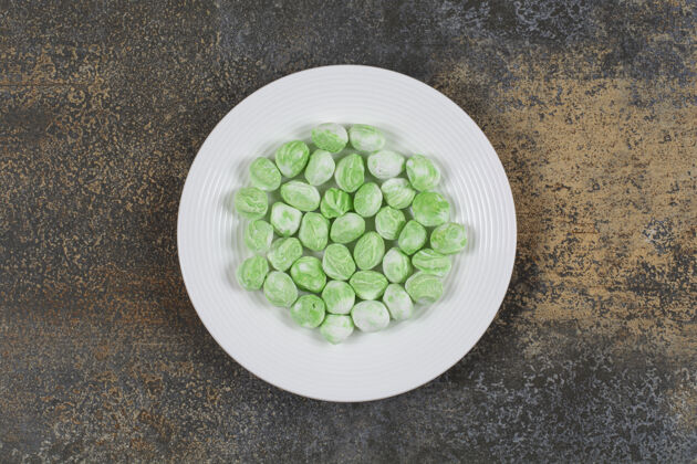 薄荷白色盘子上的绿色薄荷醇糖果香料薄荷糖果